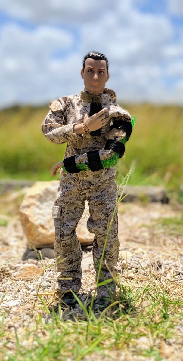 Full-figure view of neon-green Set-Lock Splint prototype on bent arm with black straps